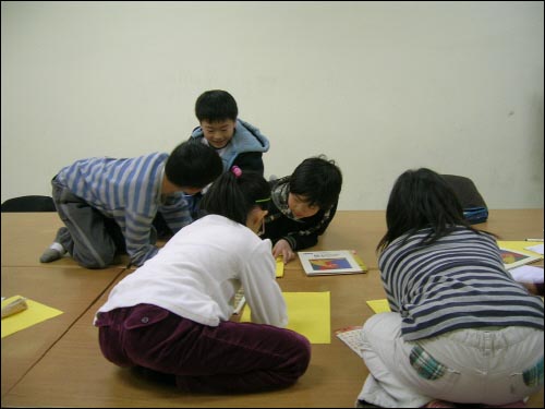 책상을 붙이자 마치 안방 같다. 노란 도화지 한 장씩을 받아들고 구상하는 아이들. 